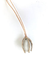 Small beach pebble caged in bronze